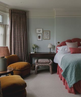 soft blue bedroom with pink headboard and bed skirt and velvet furniture