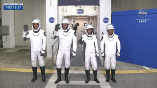 four astronauts dressed in white space suits waving