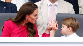 Prince Louis of Cambridge 'thumb's his nose' and sticks his tongue out at his mother Catherine, Duchess of Cambridge as they attend the Platinum Pageant on The Mall on June 5, 2022 in London, England.