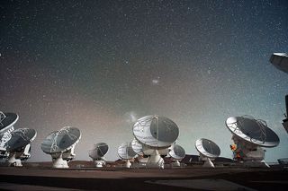 The Atacama Large Millimeter submillimeter Array ALMA by night under the Magellanic Clouds.