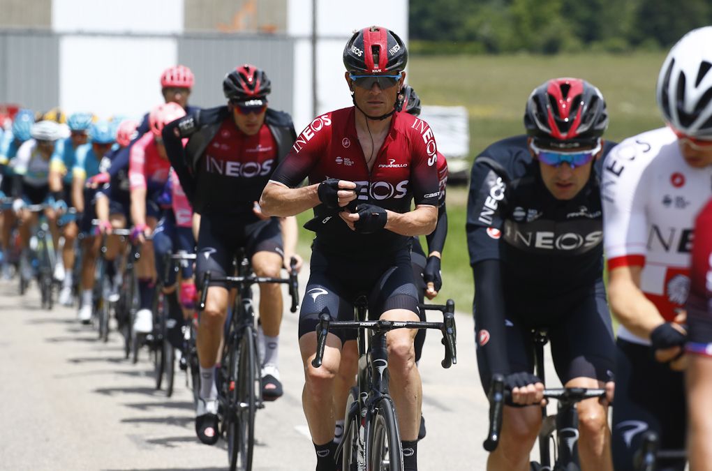 Team Ineos rides remove clothing after the rain let up during stage 6