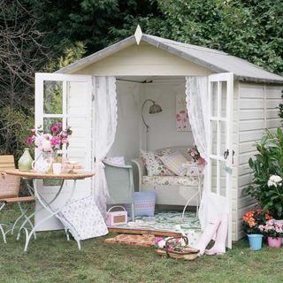 garden area with white shed and floral sofa