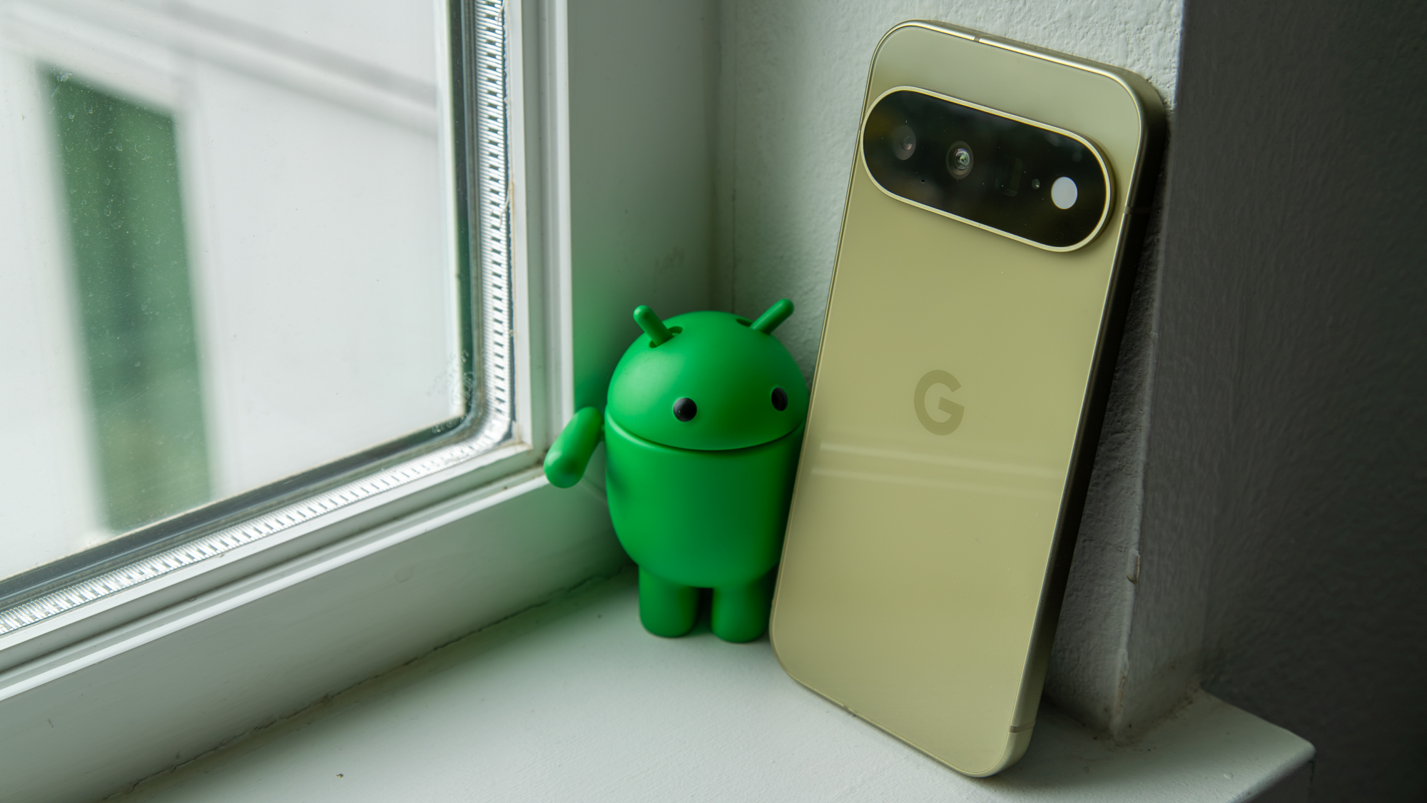 The Pixel 11 next to the Android Bot figure