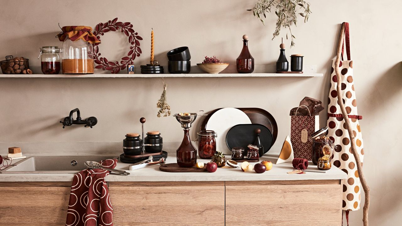 IKEA Krosamos collection, in a rustic kitchen with autumnal-coloured kitchenware on white floating shelves