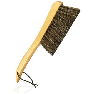 A side-on view of a soft-bristled wooden brush