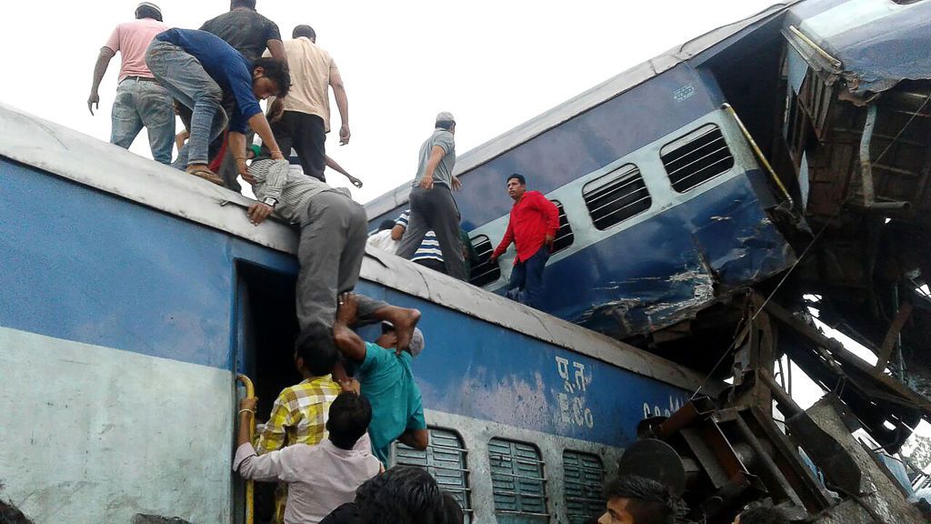 Local residents look for survivors on the wreckage of train carriages after an express train derailed near the town of Khatauli in the Indian state of Uttar Pradesh on August 19, 2017