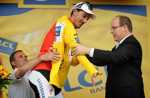 Fabian Cancellara gets some help with his yellow jersey from Bernard Hinault (L) and Prince Albert of Monaco.