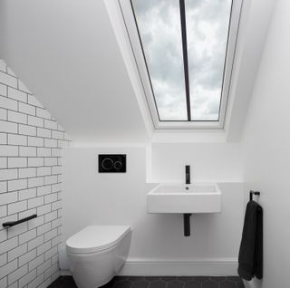 a loft conversion bathroom with a wc and basin under the eaves