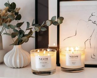 Neom Bedtime Hero candles on side with wall art and eucalyptus