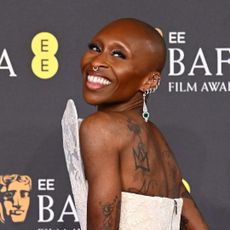 Cynthia Erivo wears a structural white lace gown on the red carpet of the BAFTAs 2025