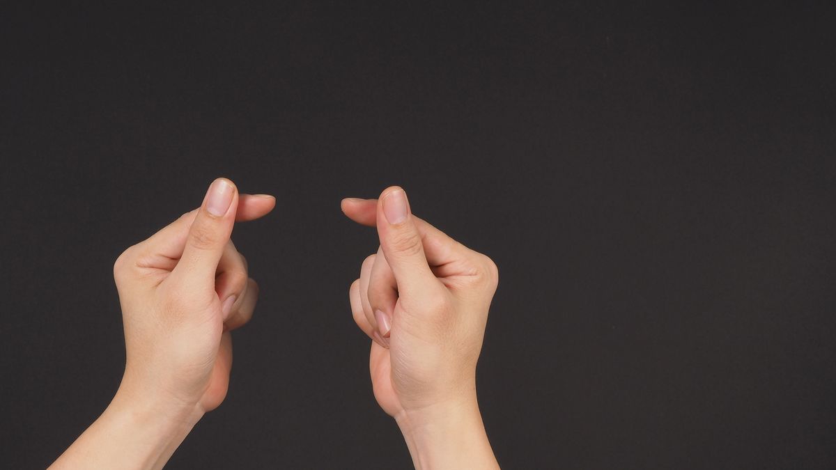 Close-up of a woman&#039;s hands as she is snapping her fingers.