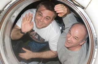 Two American astronauts waving from Russian-built Soyuz spacecraft