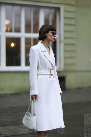 A woman wearing a white trench coat.