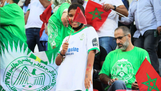 Smiling Algerian fan waves flag to support his team in the African Cup of Nations