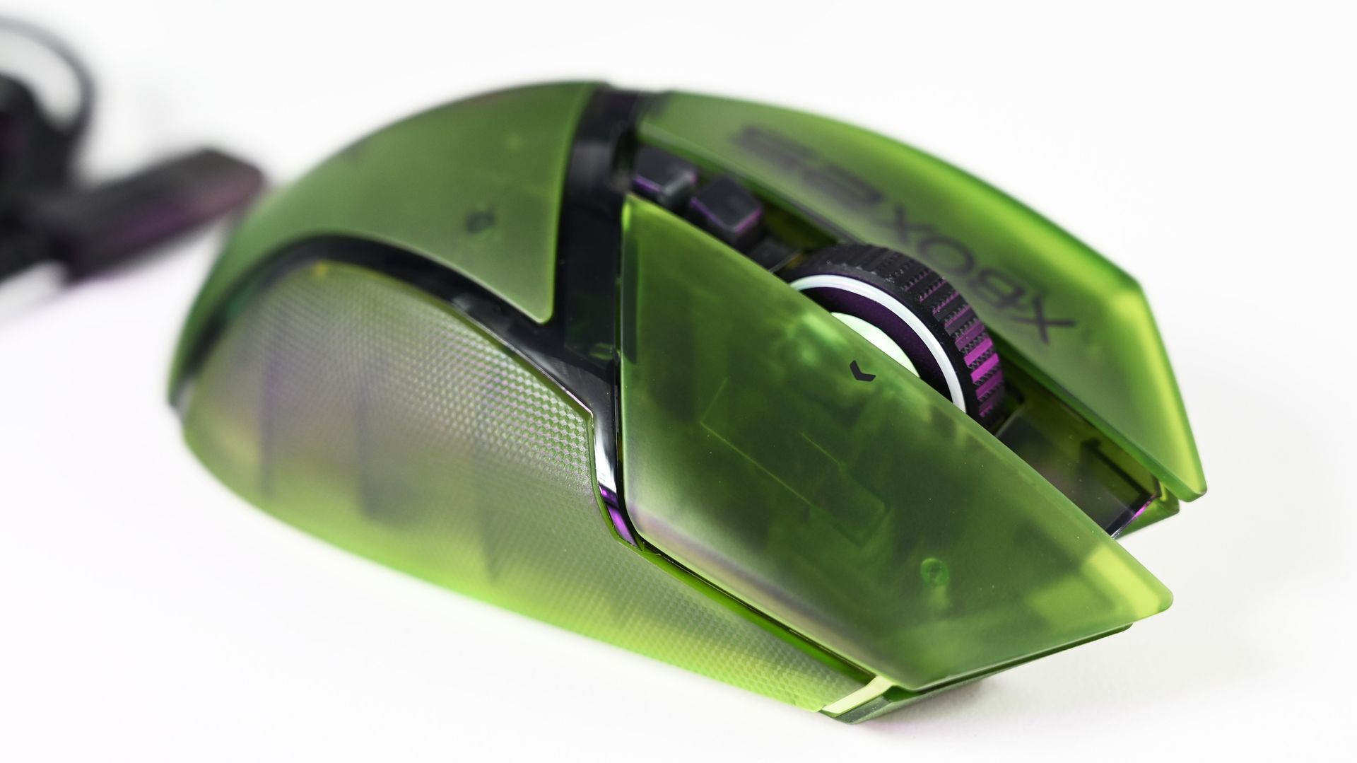 Close-up top view of the Razer Basilisk V3 Pro 35K Xbox 25th Anniversary gaming mouse featuring a translucent green shell and Xbox 25 branding.