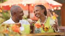 Senior Couple at restaurant drinking cocktail, smiling