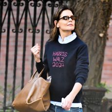 Katie Holmes wears a sweater for the Kamala Harris campaign with a leather bag and skinny jeans while walking in Manhattan