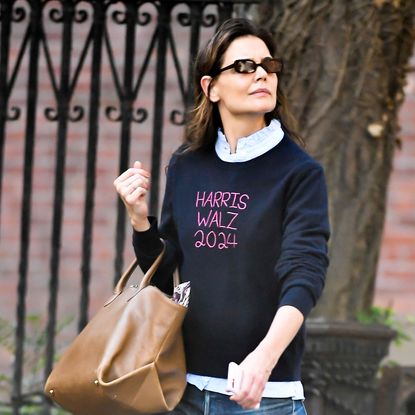 Katie Holmes wears a sweater for the Kamala Harris campaign with a leather bag and skinny jeans while walking in Manhattan