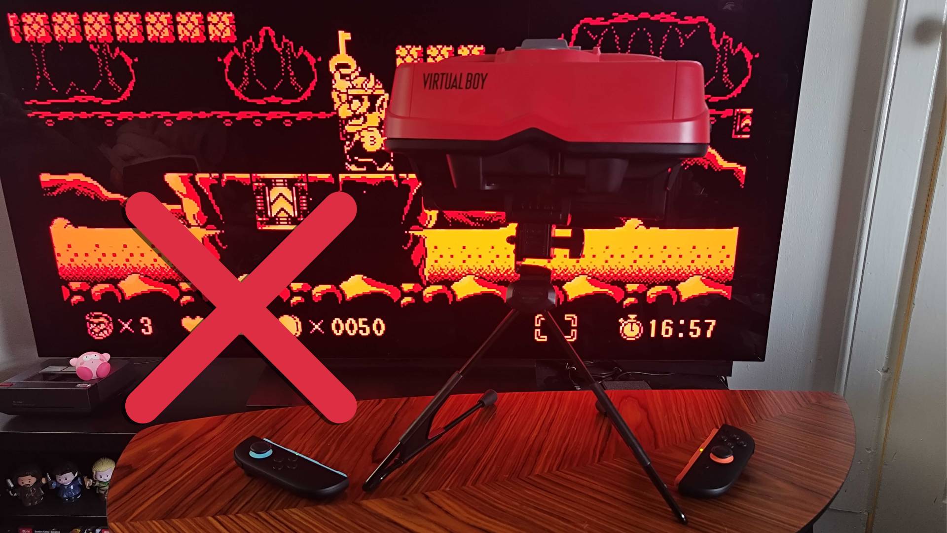 Virtual Boy with stand V-shape pointing backwards with red cross on left hand side.
