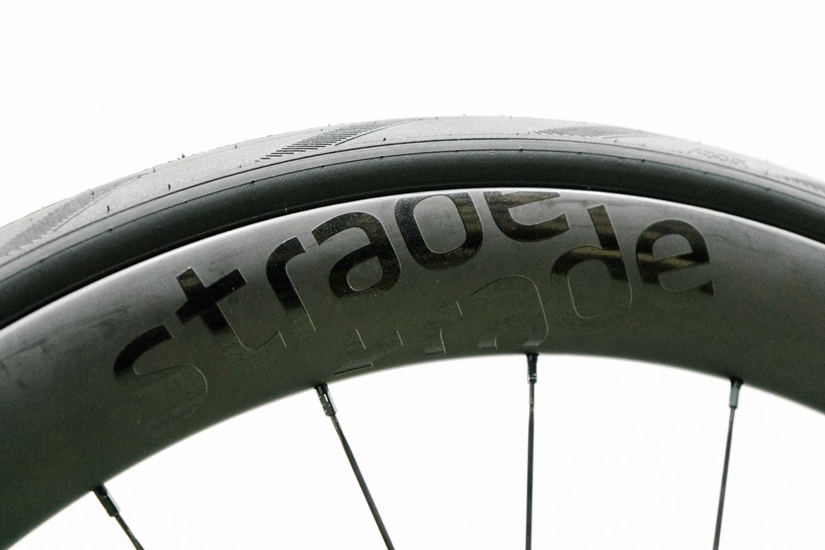 An aero road wheel stands against a white wall