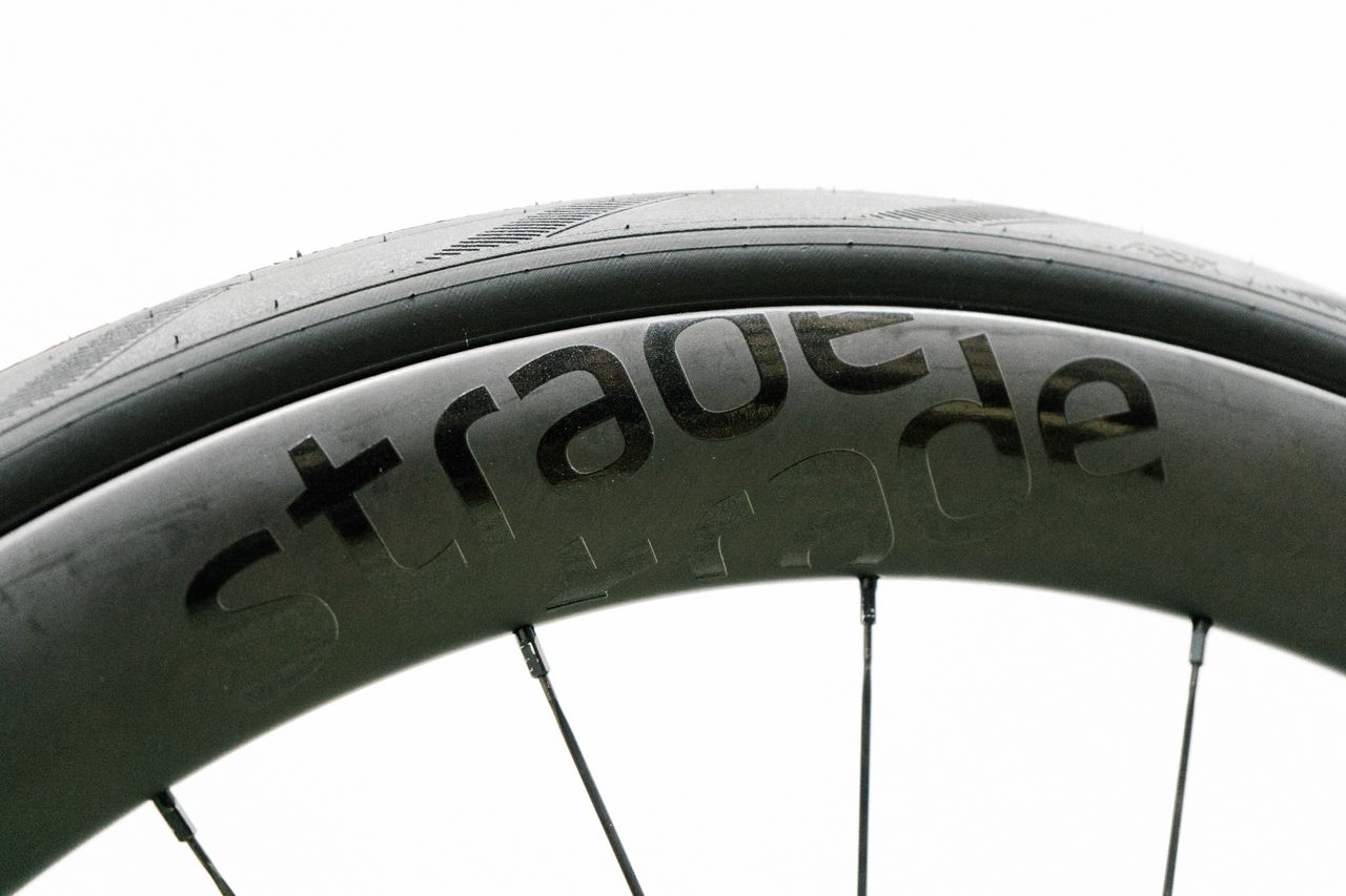 An aero road wheel stands against a white wall