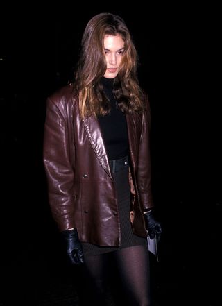 90s autumn outfits: Cindy Crawford wears a burgundy leather jacket with a miniskirt