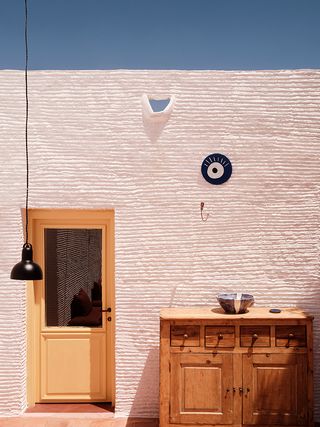 table and chairs against white wall at Bardot in Antiparos
