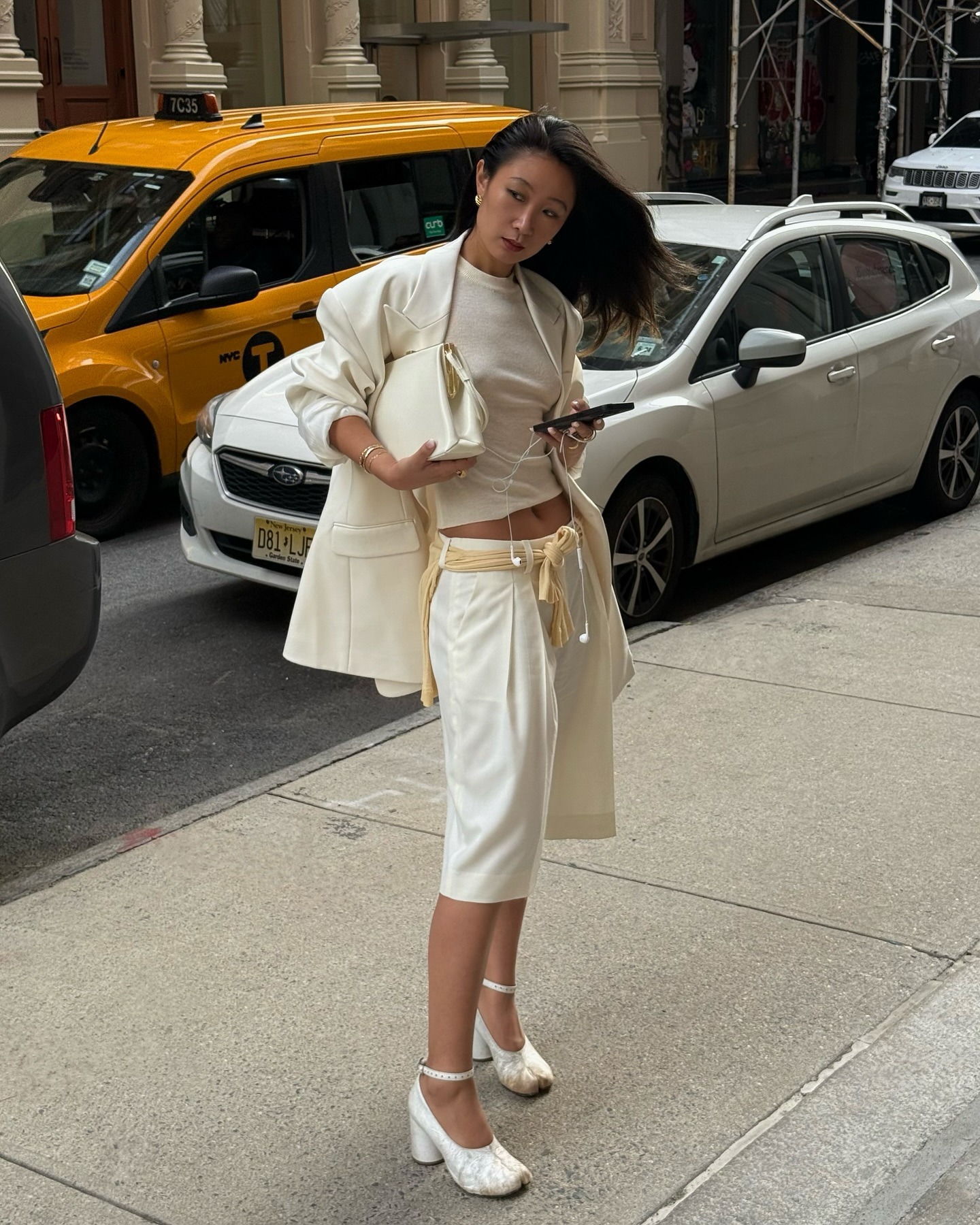Caroline Lin wears long white tailored shorts.