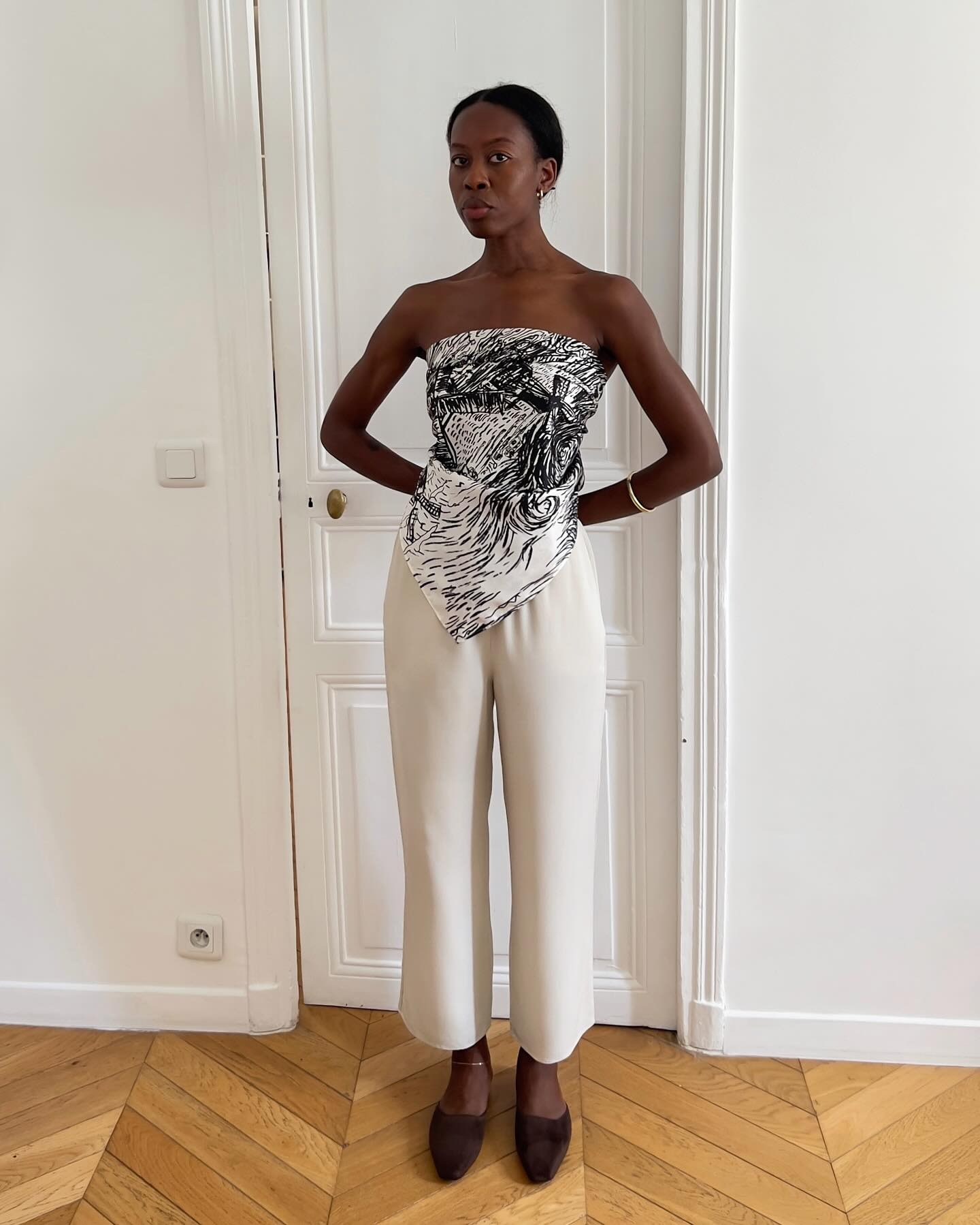 European influencer wearing a scarf top and silky white pants