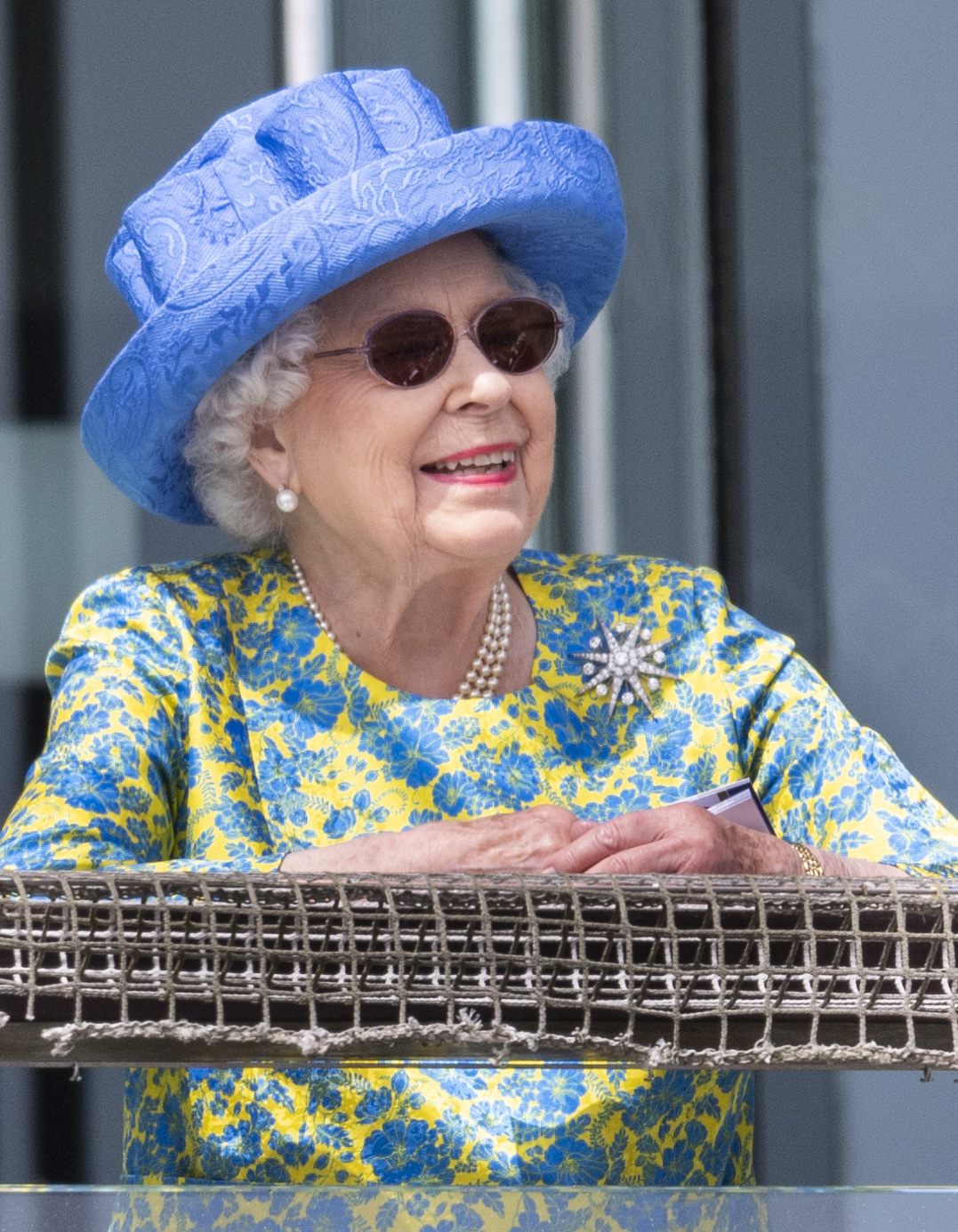 Queen Elizabeth in a blue hat and floral dress at the Epsom Derby