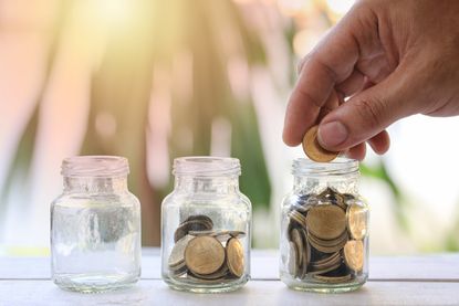 hand of person putting money into a jar