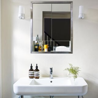 white wall wash basin and mirror on wall