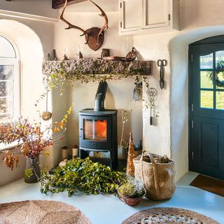 Wood burning stove in a classic country living room with large hearth and foliage