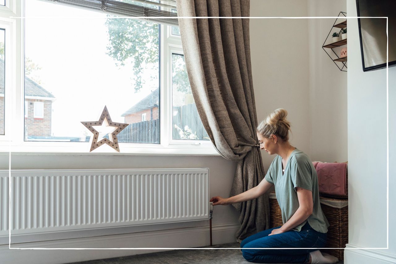 woman adjusting the valve on a radiator at home