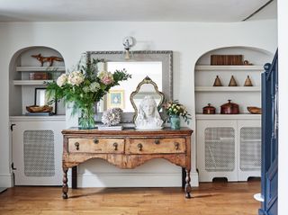 entrance hall with alcove shelving and antique console table with flowers and white bust statue