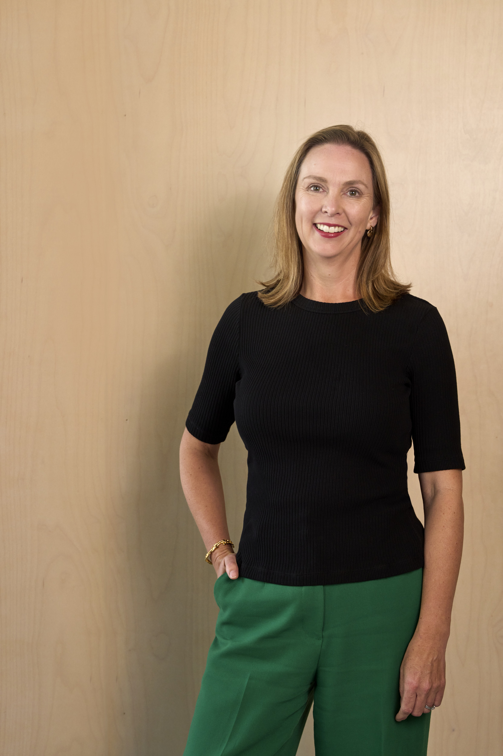 Sarah Bryant wearing black top and green trousers