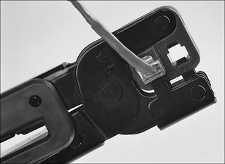 Figure 17.13: Use the crimping tool to squeeze the 8P8C (RJ-45) plug onto the cable