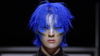 Man in blue hair in Just Makeup season 1 beauty survival show on Prime Video