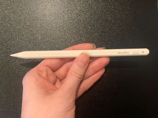 A white NovaPlus A8 Duo stylus being held in a hand and used on an iPad