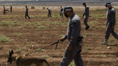 Israeli prison officers conduct a search after the break-out