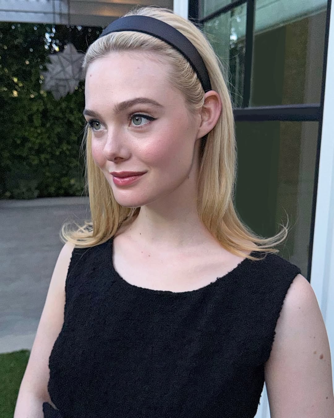Elle Fanning Is So CBK-Coded in a '90s-Inspired Headband and a Vintage Balenciaga LBD with long blonde hair, sheer tights, and black patent pumps