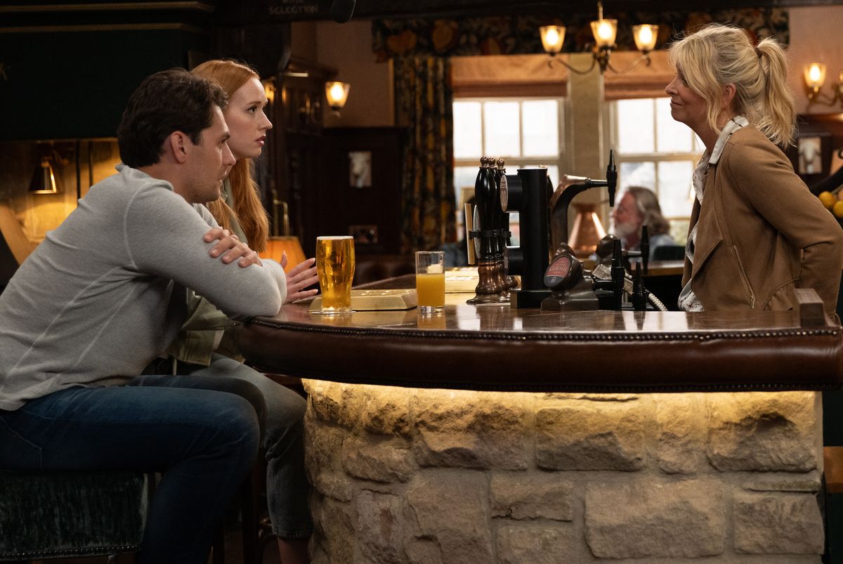 Charity Dingle talks to Chloe and Mack in the pub