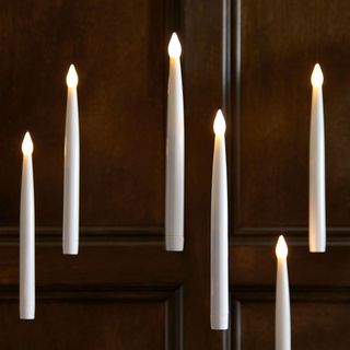 Six floating candles in front of wood panelling