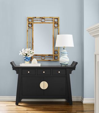 A blue wall and a black credenza