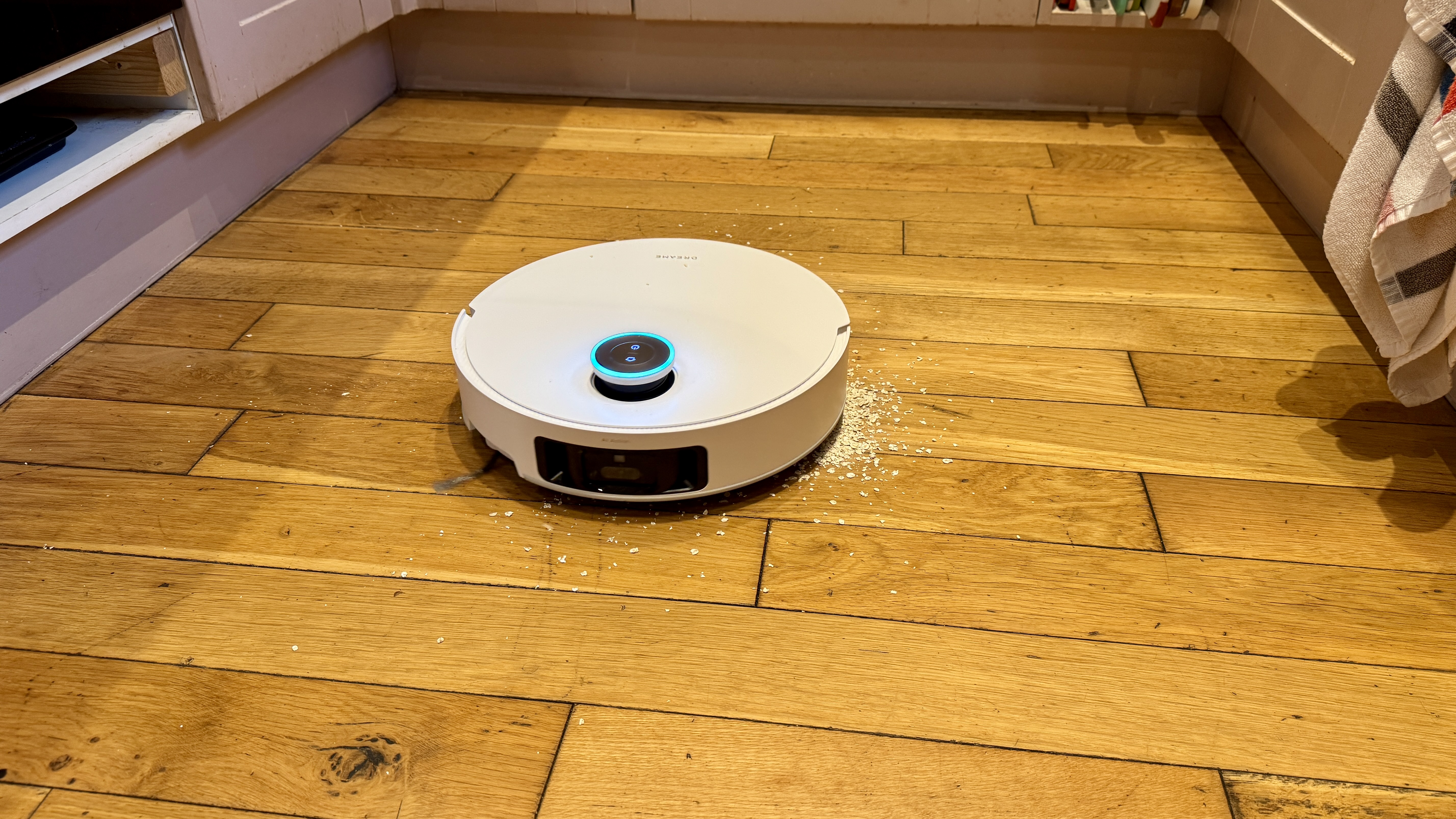 Dreame Matrix10 Ultra robot vacuum vacuuming oats from a wooden floor