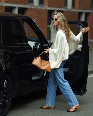 Woman in satin top and jeans.