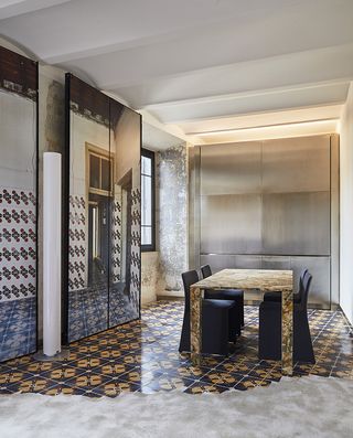 The Rooms of Rome dining area with mosaic tiles on floor and wall, large mirrors and marble table