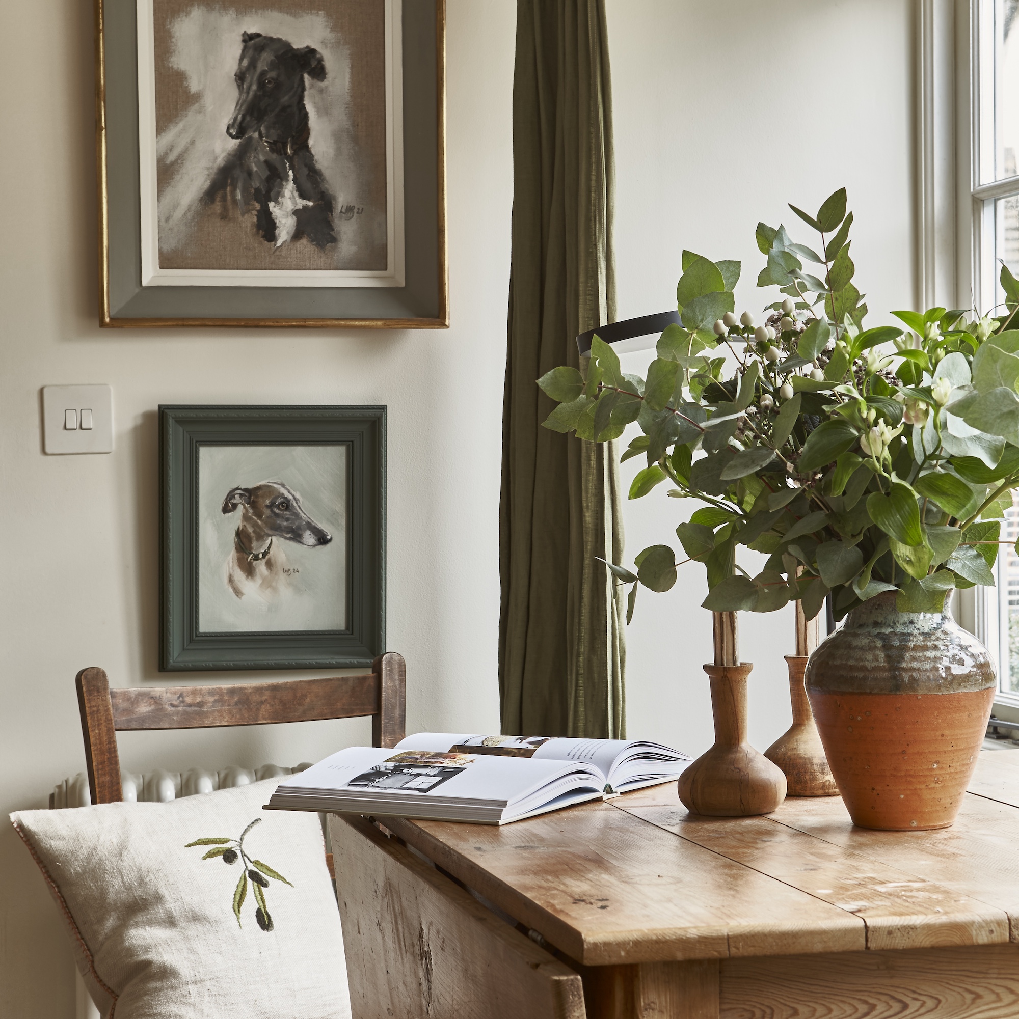 galley kitchen with small island with green metal frame and spiral staircase