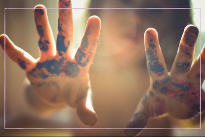 A child's hands covered in paint