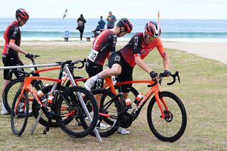 Ineos Grenadiers team are getting on their bikes which are on a bike rack